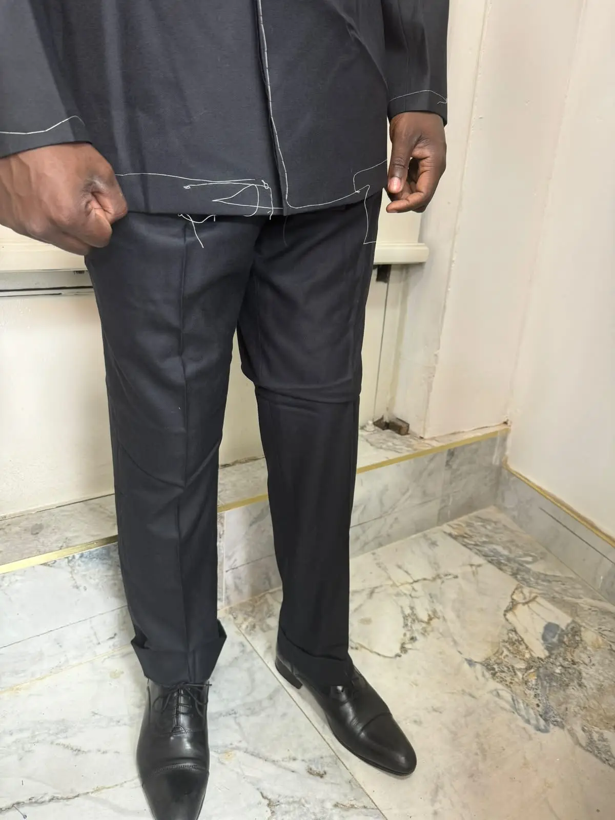 Client wearing a basted test suit during a fitting