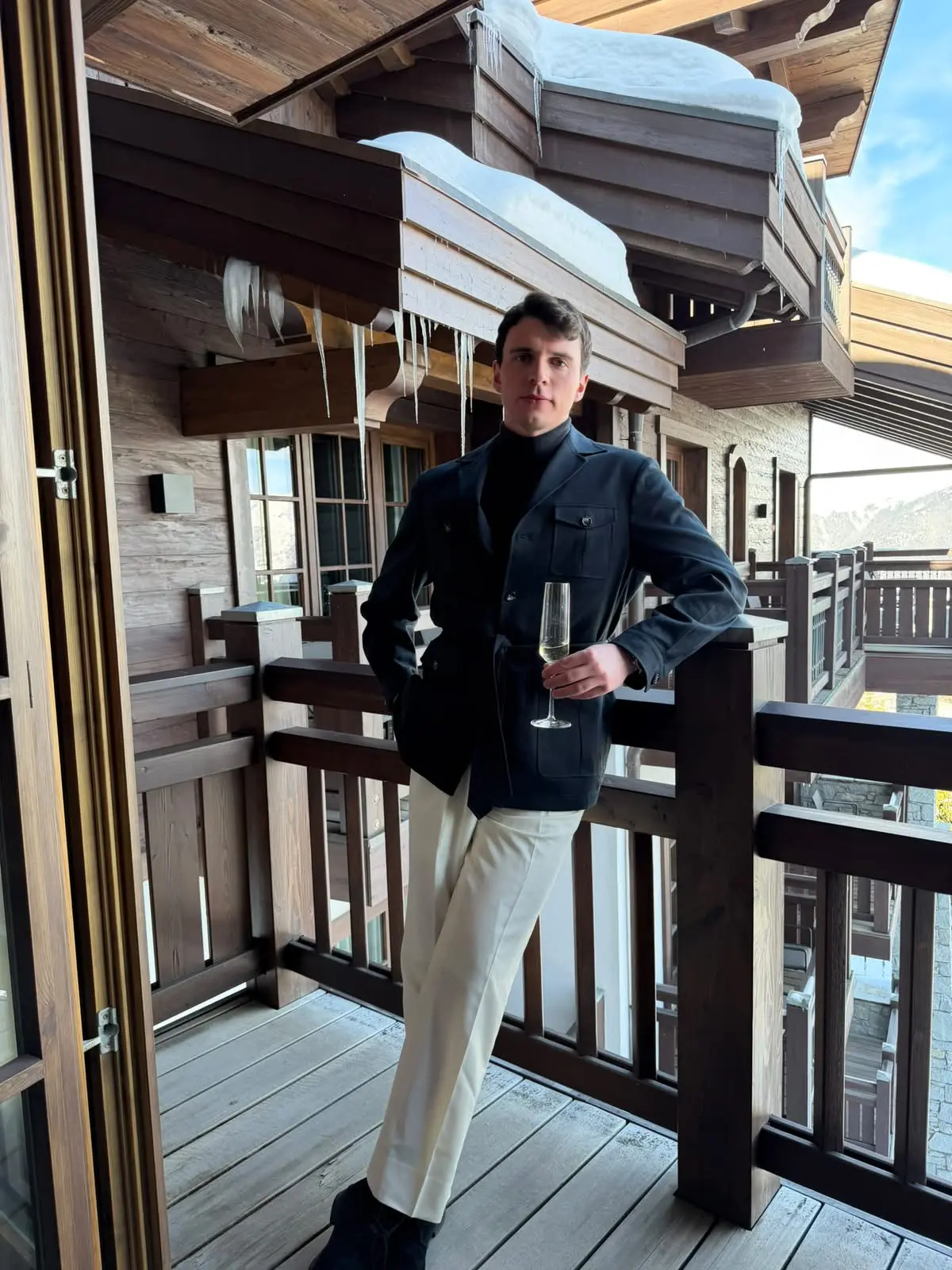 Navy safari jacket worn with a roll neck and cream trousers