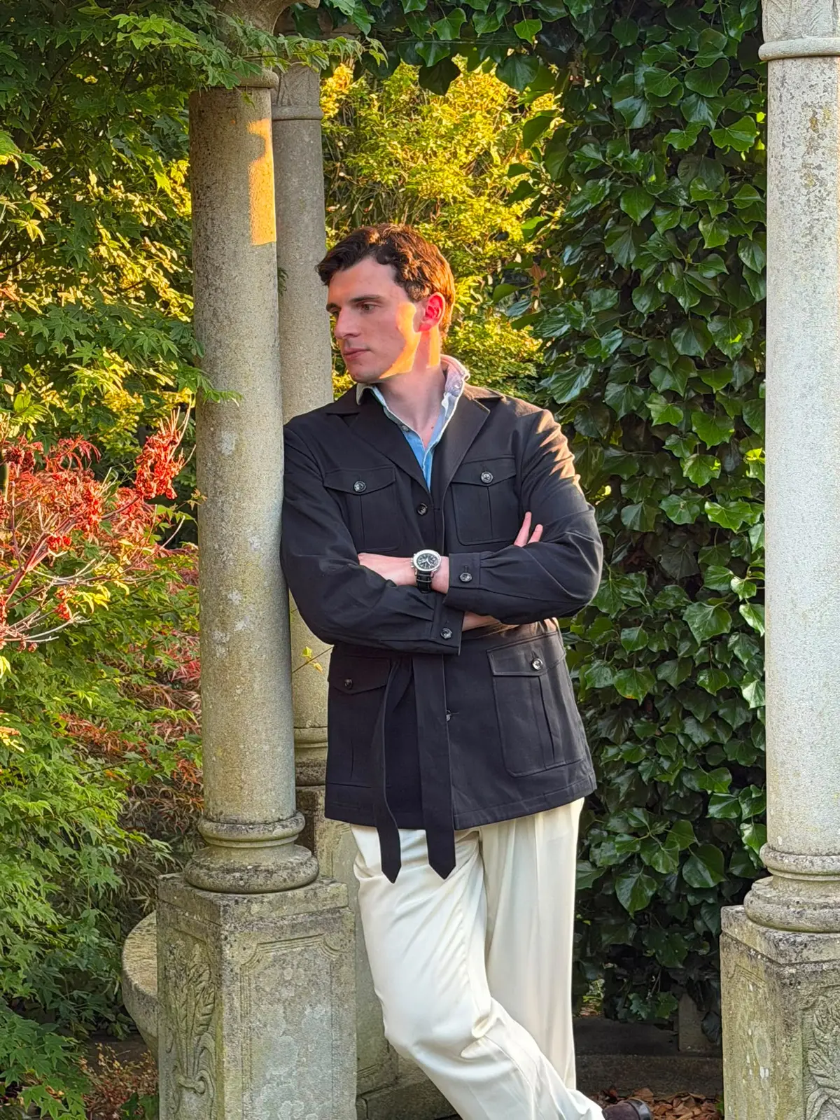 Client wearing a belted navy safari jacket with cream trousers
